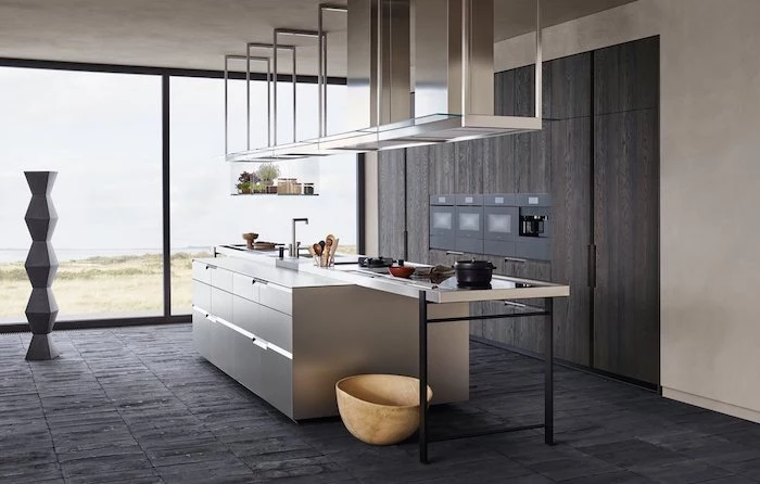 modern kitchen, silver kitchen island, dark wooden cabinet, black tiled floor, tall windows, hanging lamps