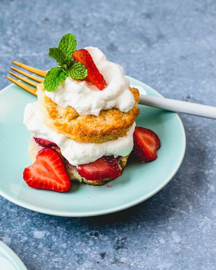 strawberry shortcake placed on turquoise plate cookcout desserts fork on the side placed on grey surface