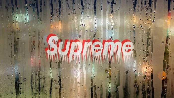 supreme wallpaper logo written in red and white letters dripping down fogged glass with raindrops on it for background