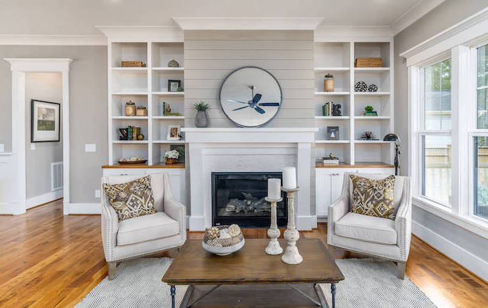 white carpet on wooden floor, modern farmhouse interior, two white armchairs, wooden coffee table, placed in front of a fireplace