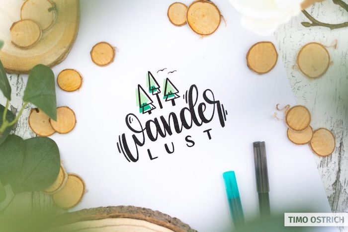 wanderlust written in black hand lettering three small trees drawn above it white background