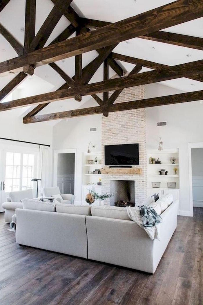 exposed wooden beams on white ceiling, farmhouse living room furniture, white furniture set, placed in front of a fireplace