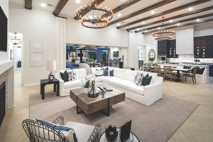 white corner sofa with colorful throw pillows, wooden coffee table, farmhouse living room furniture, exposed wooden beams on white ceiling