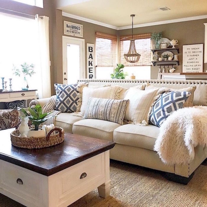 white sofa with blue and white throw pillows, industrial farmhouse decor, wooden coffee table, light grey walls