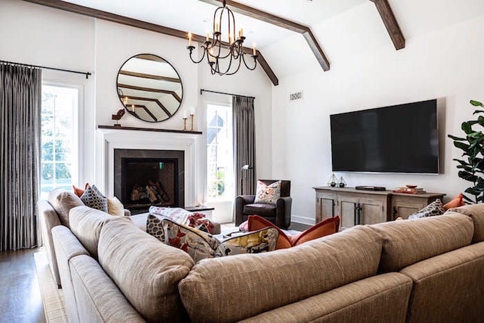 brown corner sofa with colorful throw pillows, farmhouse chic decor, placed in front of a fireplace