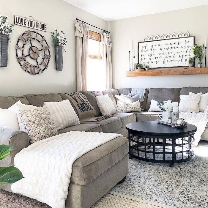 grey corner sofa, farmhouse chic decor, black round coffee table, lots of throw pillows