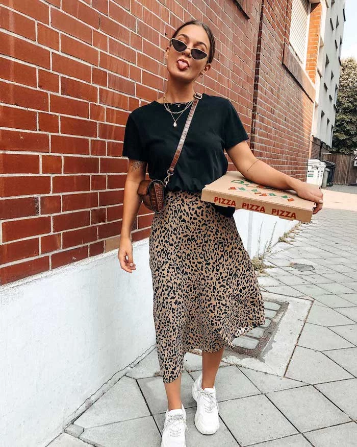 woman carrying box of pizza wearing leopard print skirt black t shirt white sneakers sunglasses cute casual outfits small leather bag