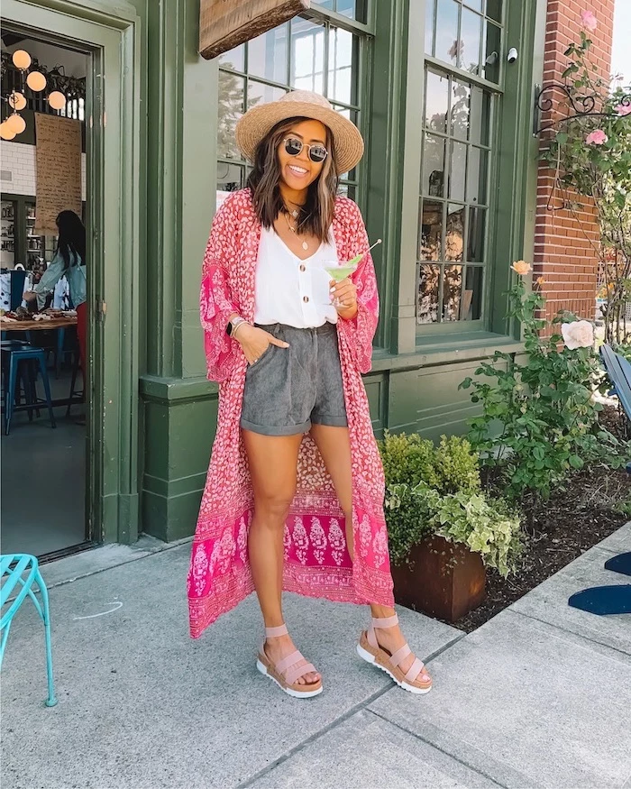 woman wearing dark grey shorts white top long pink kimono cute trendy outfits pink sandals and hat