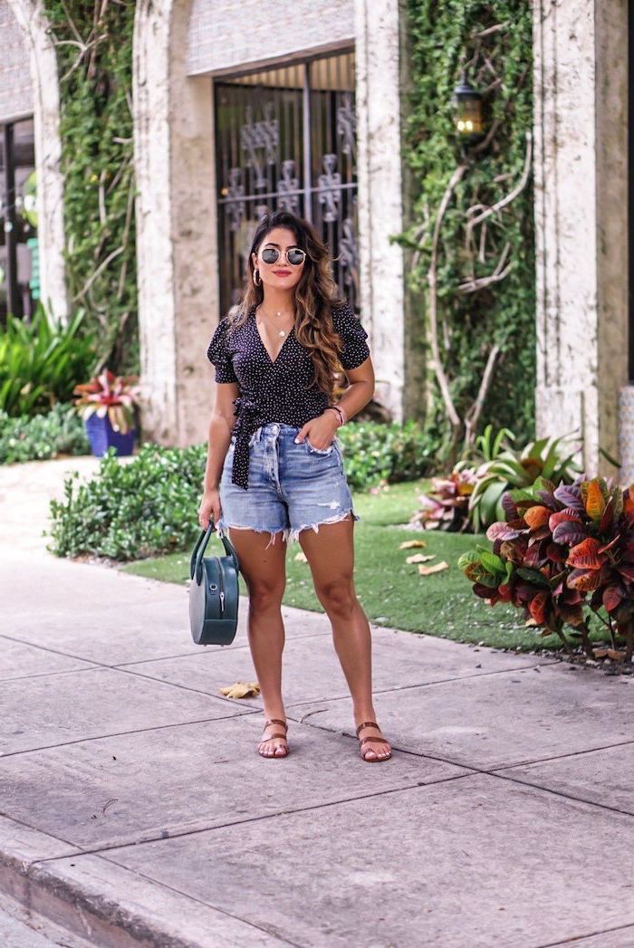 woman wearing floral black top denim shorts cute simple outfits dark green bag sunglasses brown leather sandals