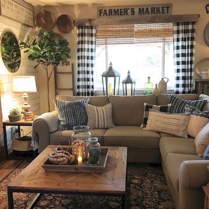 grey corner sofa with throw pillows, farmhouse chic decor, wooden coffee table, colorful carpet on wooden floor