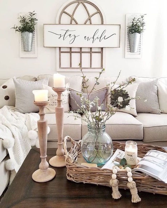 white walls, white corner sofa with lots of throw pillows, wooden coffee table, country farmhouse decor