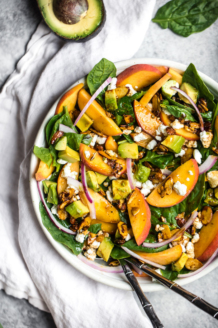 avocado peach spinach onion walnuts crumbled feta cheese in white bowl with two spoons on the side dinner salad recipes