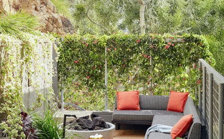 backyard paver ideas black metal garden sofa with black cushions orange throw pillows next to fire pit surrounded by greenery