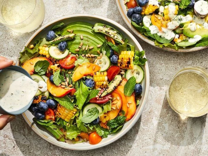 baked corn cherry tomatoes cucumbers avocado peack and blueberries summer salad recipes inside white bowl