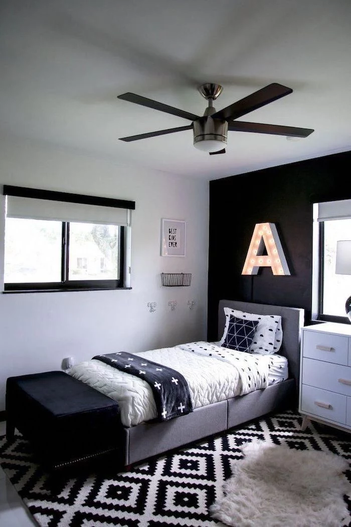 black accent wall boys room colors led letter a hanging above the bed with white bed linen white and black carpet
