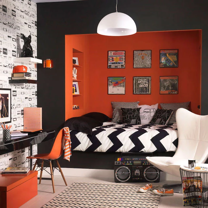 black and orange walls bedroom ideas for teenage guys with small rooms bed nook colorful posters hanging above the bed black desk with orange chair