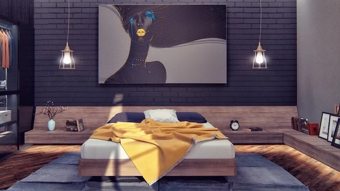 black brick wall with art above bed with yellow blanket dark blue pillows bedroom wall decor ideas floating wooden shelves with led lights wooden floor with blue carpet