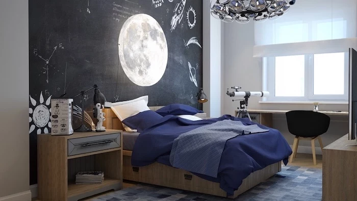 black chalkboard wall with photo of the moon on it boys bedroom furniture wooden bed with blue sheets telescope next to wooden desk