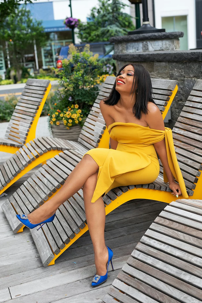 black haired woman wearing yellow strapless dress blue satin shoes cocktail dresses for weddings sitting on wooden lounge chair