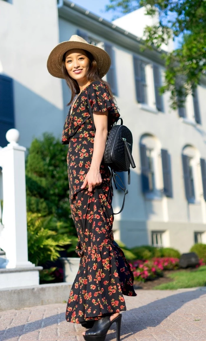 black long dress with red flowers worn by brunette woman long summer dresses black leather shoes and backpack