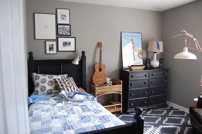 black wooden bed frame and drawers teen boy bedroom furniture grey walls framed photos above the bed guitar on the night stand