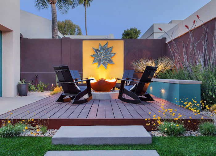 black wooden lounge chairs arranged around fire pit on wooden floor concrete patio ideas lots of plants