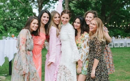 blonde and brunette women photographed together wearing different dresses with lace and flowers wedding guest outfits bride in the middle