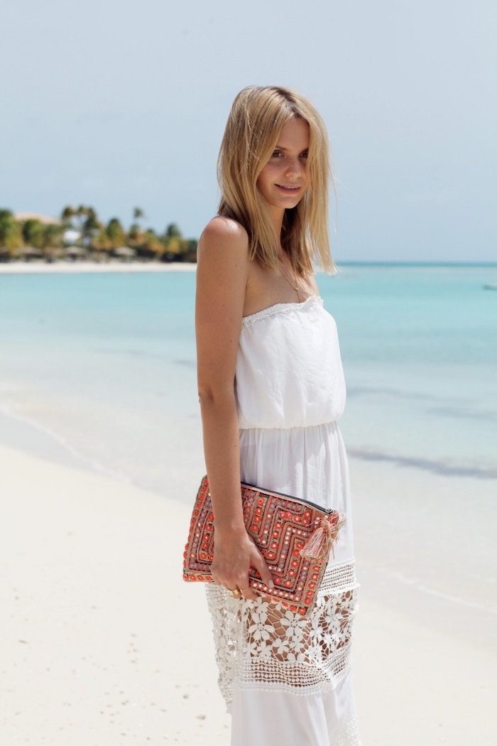 blonde woman standing on the beach casual summer maxi dresses wearing long strapless white dress with lace