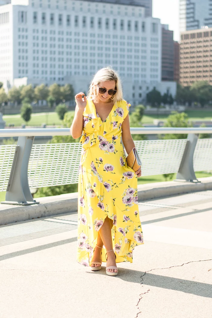 blonde woman wearing long yellow wrap around dress with purple flowers long sleeve wedding guest dresses nude sandals