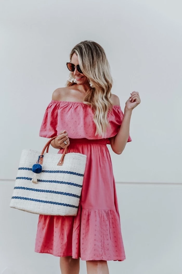 blonde woman with long wavy hair wearing pink strapless dress white bag summer beach dresses