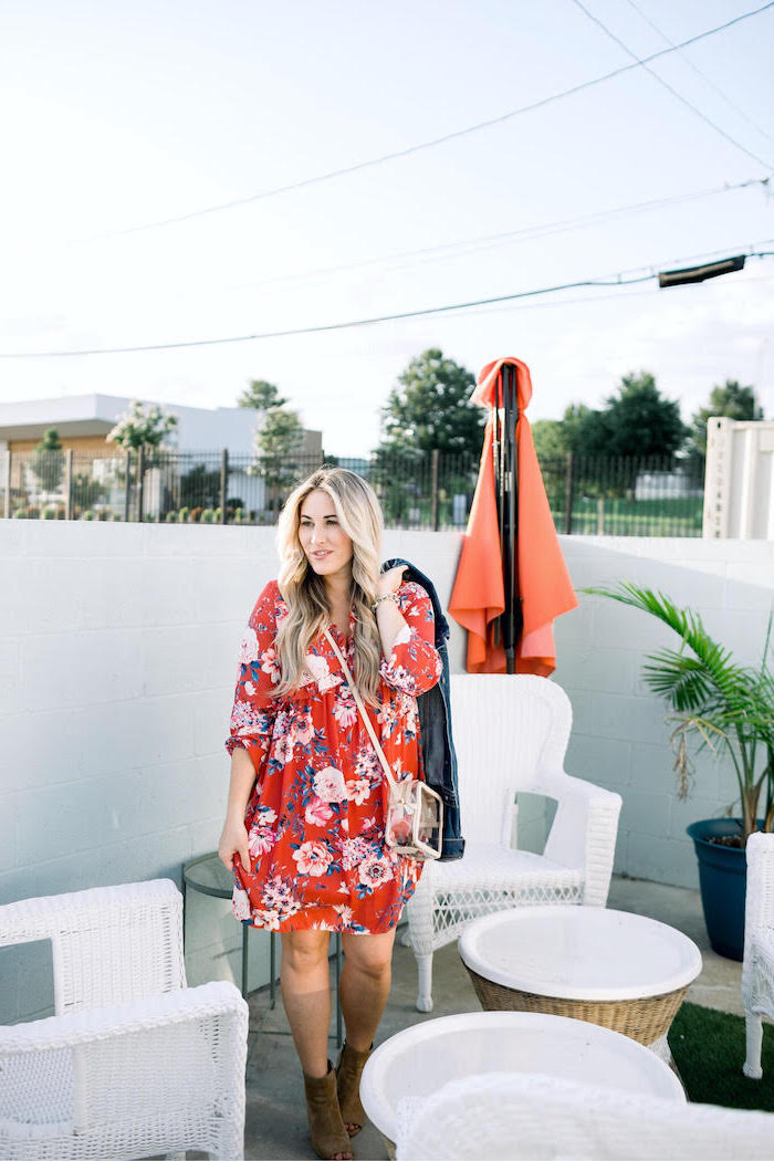 blonde woman with long wavy hair wearing red dress with pink flowers cute summer dresses standing on balcony