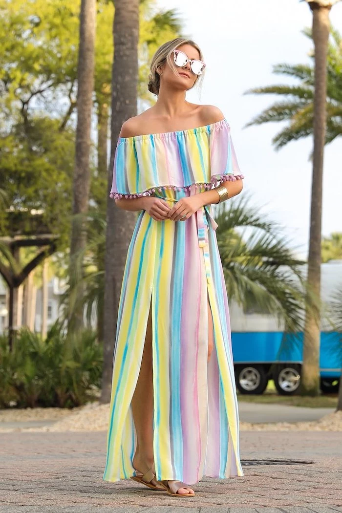 blonde woman with low updo wearing sunglasses womens dresses long dress in pink blue and yellow bare shoulders