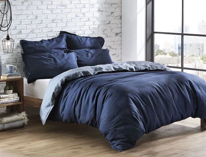 blue bed sheets on wooden bed frame bedroom ideas for teenage guys with small rooms brick wall behind it wooden floor