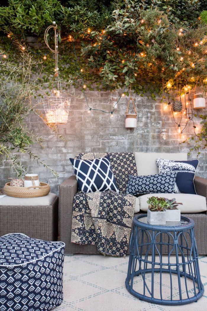 blue coffee table and throw pillows ottoman patio decor ideas garden furniture set strings of lights hanging on brick wall