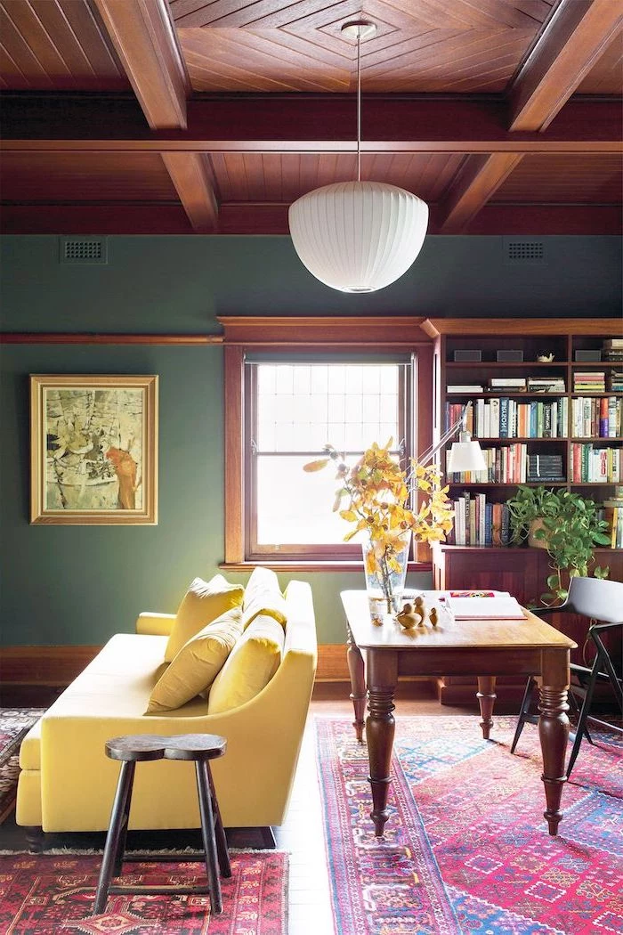 blue walls wooden ceiling floor living room wall colors yellow sofa wooden desk bookshelf colorful carpets