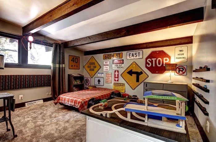 boys bedroom ideas expsoed wooden beams on white ceiling large grey carpet different road signs on the wall behind the bed