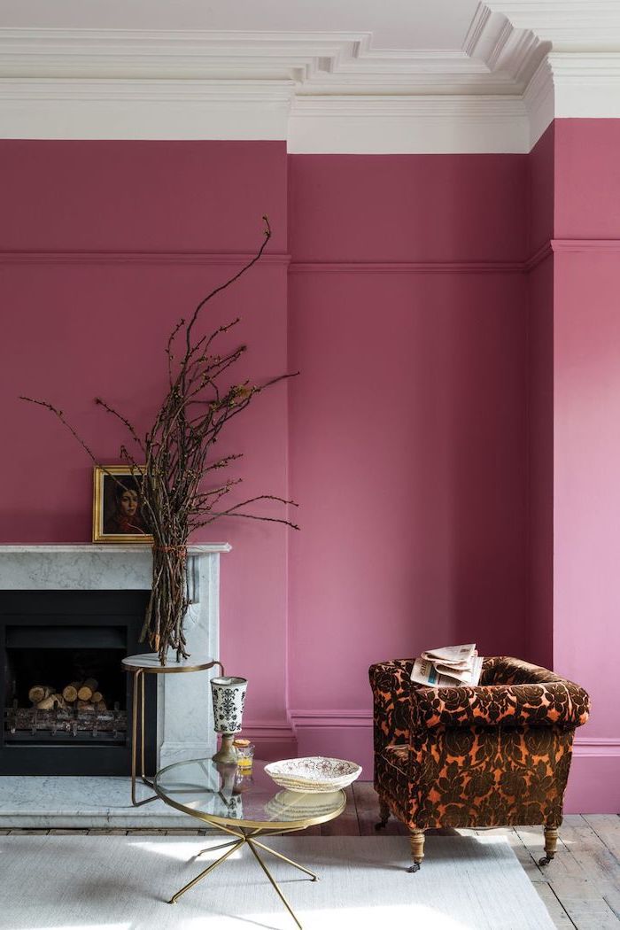 brown orange armchair in front of fireplace glass coffee table neutral color palette walls painted in pink