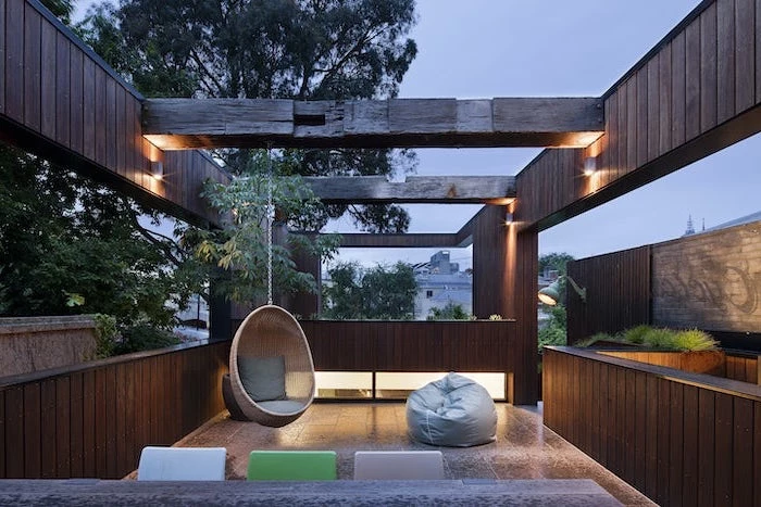concrete patio ideas wooden beams wooden swing and grey puff chairs under them on tiled floor