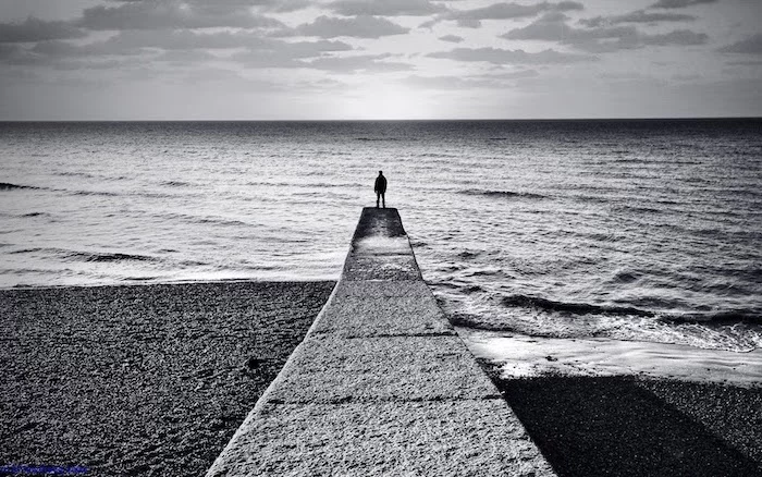 cool wallpaper hd black and white photo of man standing at the end of pier looking at the ocean