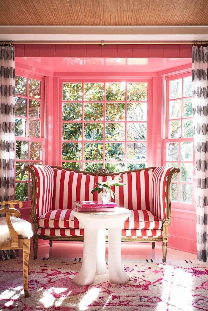 curtains in black and white neutral color palette walls painted in pink red and white striped sofa white coffee table