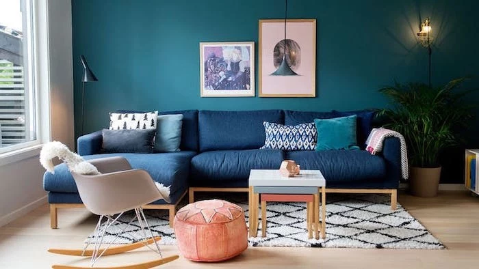 dark blue corner sofa turquoise wall with wall art interior paint colors white and black carpet on wooden floor orange ottoman