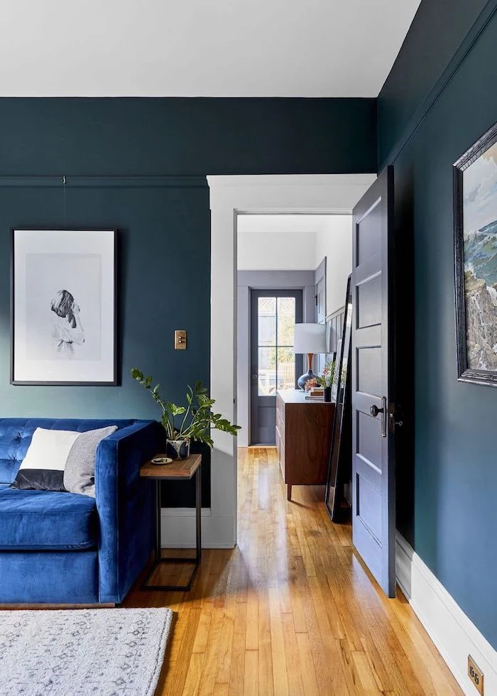 dark blue walls wooden floor with grey carpet living room paint color ideas blue velvet sofa wall art