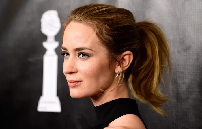 emily blunt with brunette hair with caramel highlights in ponytail haircut for thin hair to look thicker wearing black dress on the red carpet