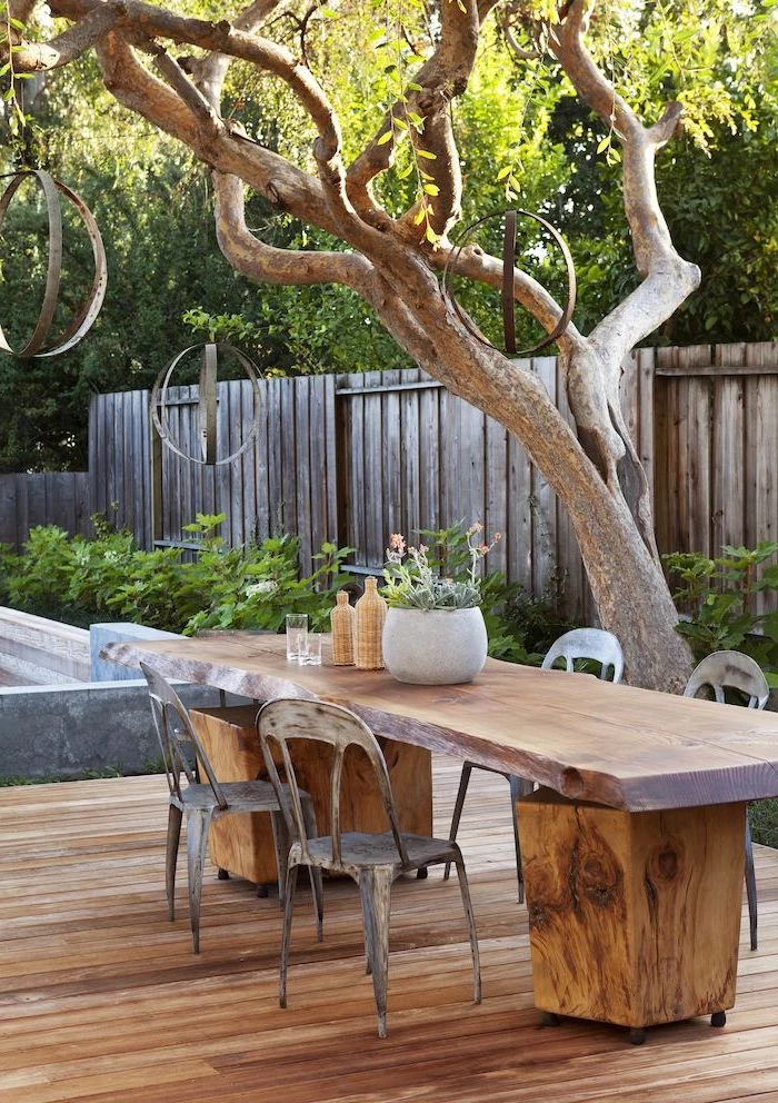 farmhouse modern decor patio cover ideas wooden table and chairs on wooden floor under tree with metal chandeliers