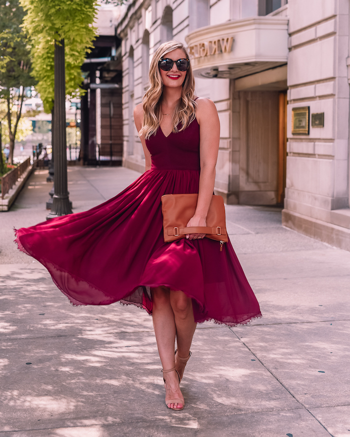 formal dresses for weddings blonde woman wering midi burgundy dress nude sandals brown leather bag