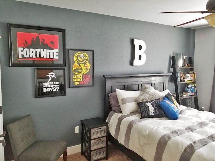 fortnite poster and throw pillows grey accent wall letter b hanging above the bed boys room colors small bookcase next to the bed