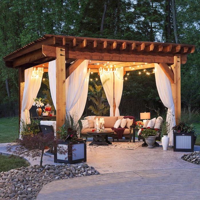 garden furniture set with beige cushions under a wooden pergola backyard patio ideas white curtaint strings of lights