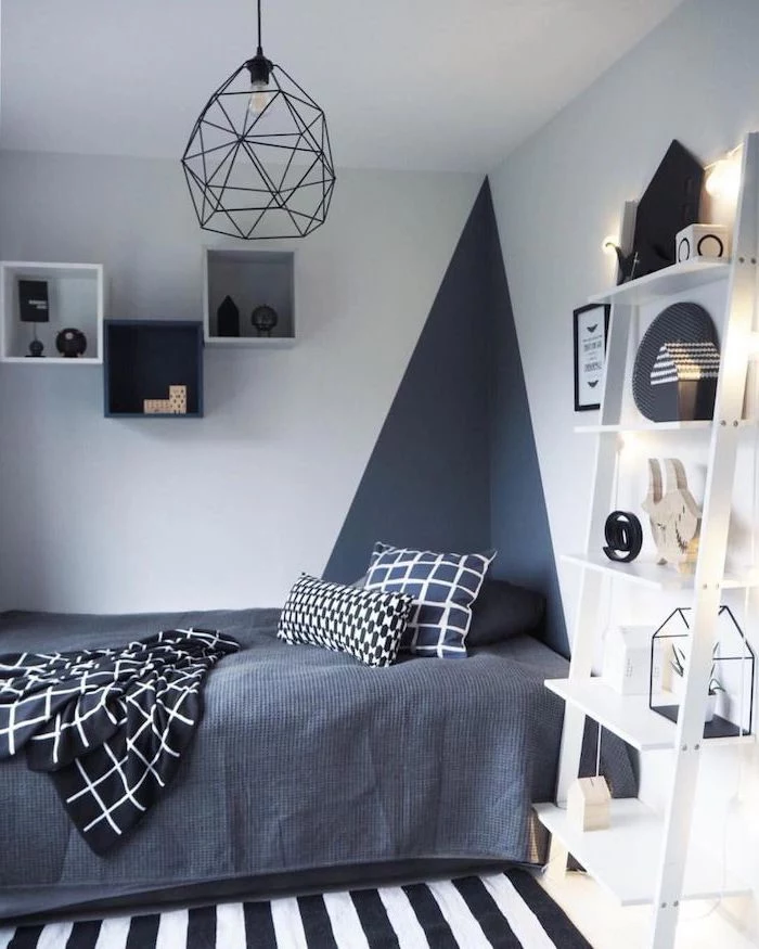 geometric wall design bookshelves on the walls boys room colors dark grey bed sheets white wooden bookcase next to the bed