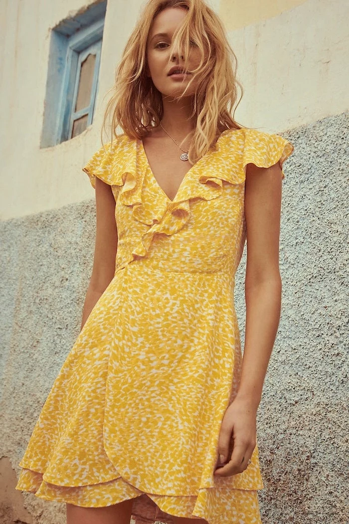 girl with medium length blonde wavy hair wearing yellow wrap around dress womens casual summer dresses