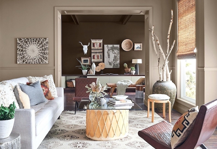 glass on top of ottoman coffee table in front of white sofa two brown leather armchairs room paint colors beige brown walls